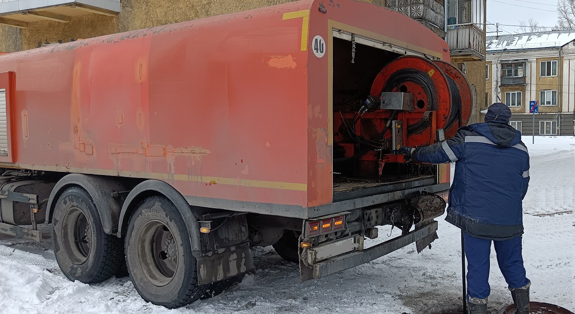 Каналопромывочная машина и работник прочищают засор в канализационной системе в Белгороде